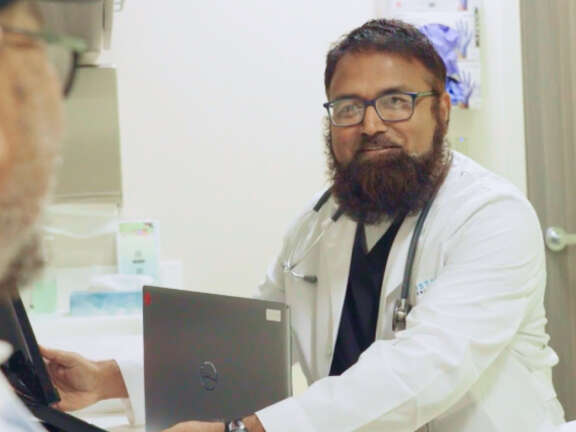 Smiling Male Doctor Examining Patient