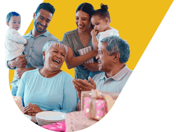 Multigenerational Latinx family sitting at table, laughing and celebrating